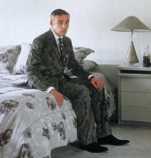 here is mike topp sitting on a bed looking upset, most likely because he just fell into a puddle of ink and ruined his suit